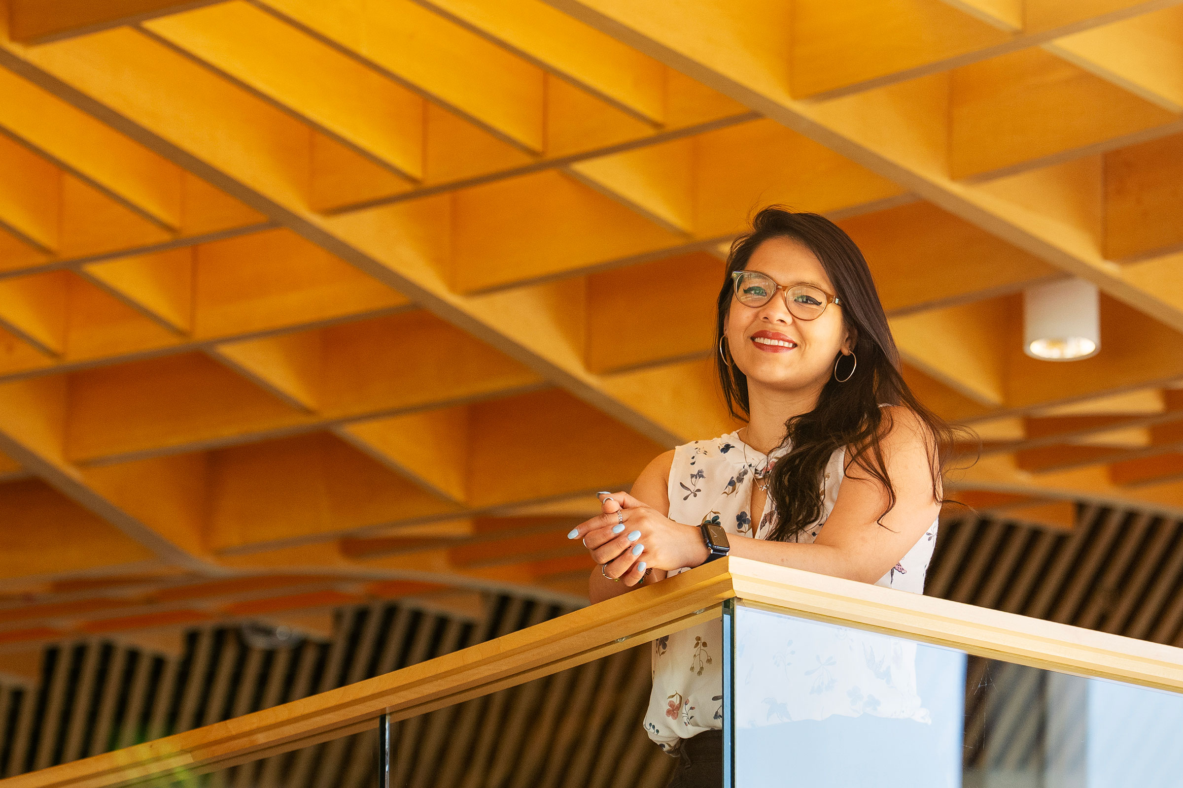 A young woman stands by a railing