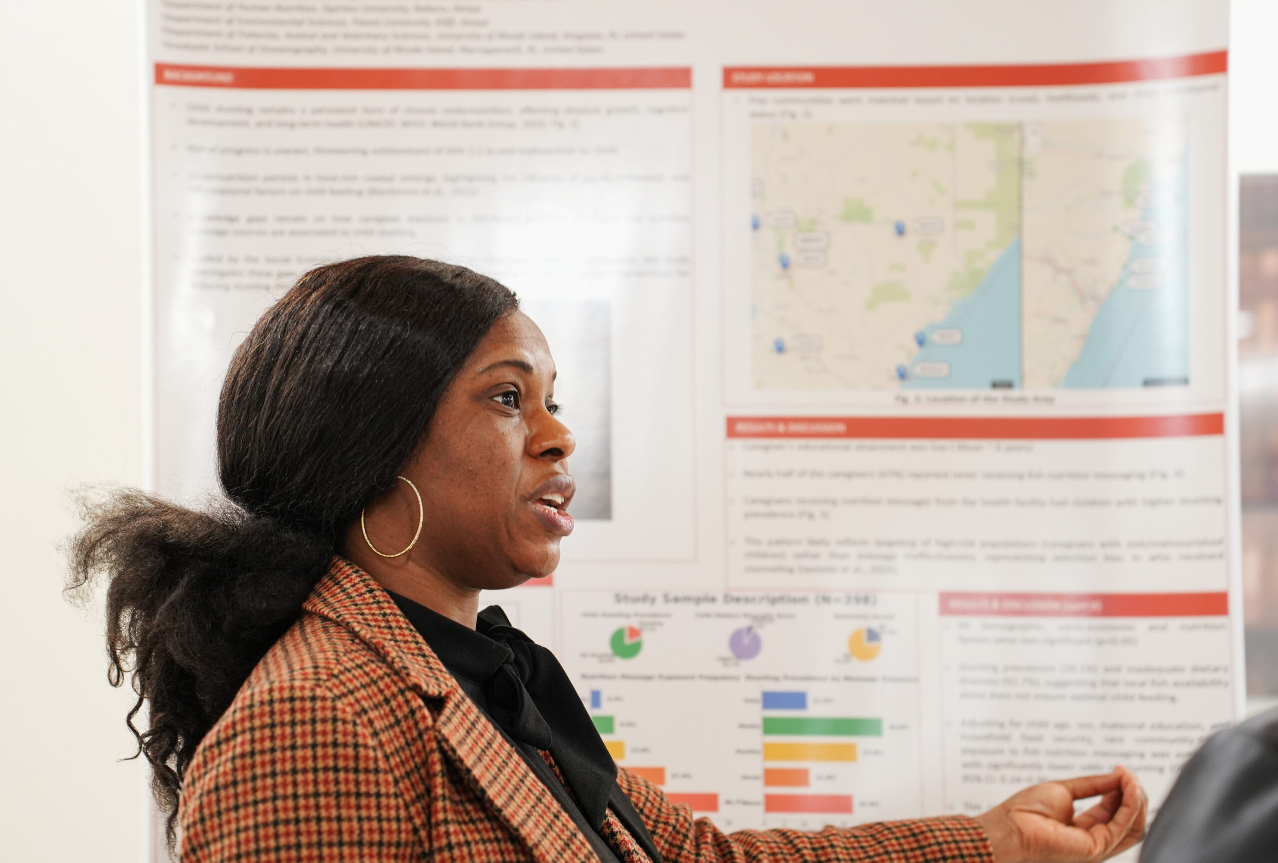 A woman stands before a research poster.