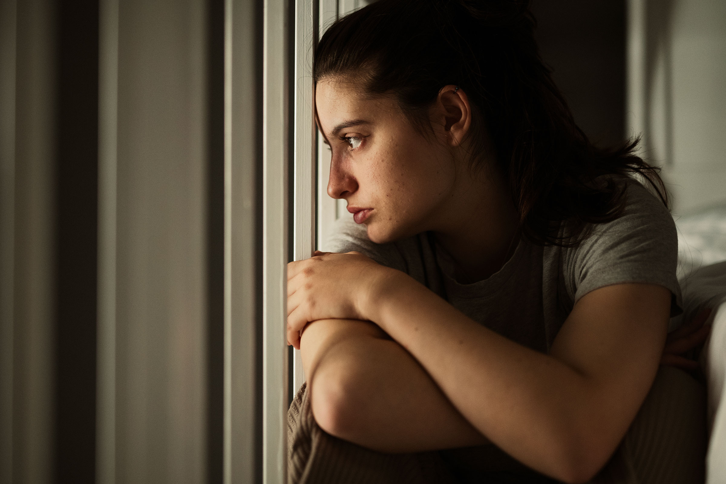 Young woman gazing out the window.