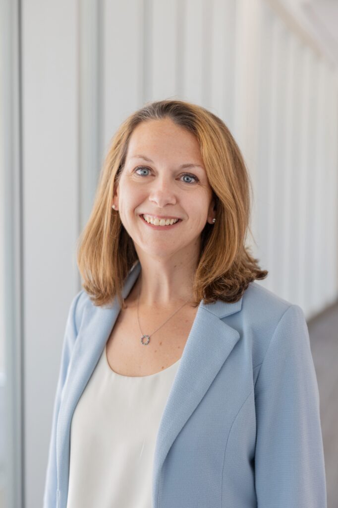 Dr.Karen Joynt Maddox portrait. She has brown hair and a blue jacket with a white blouse