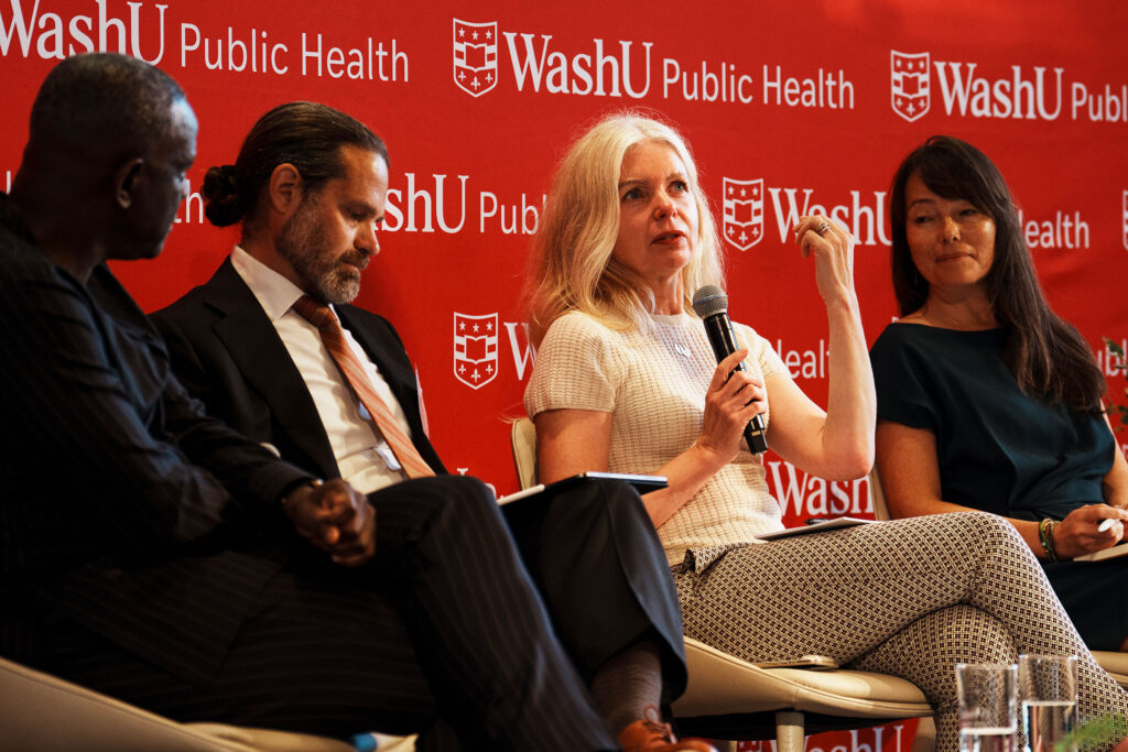 Four people sit on a stage for a panel discussion