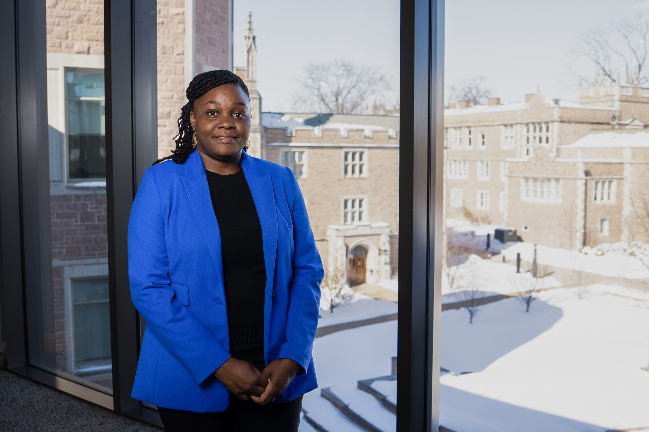 photo of female PhD student standing by a window