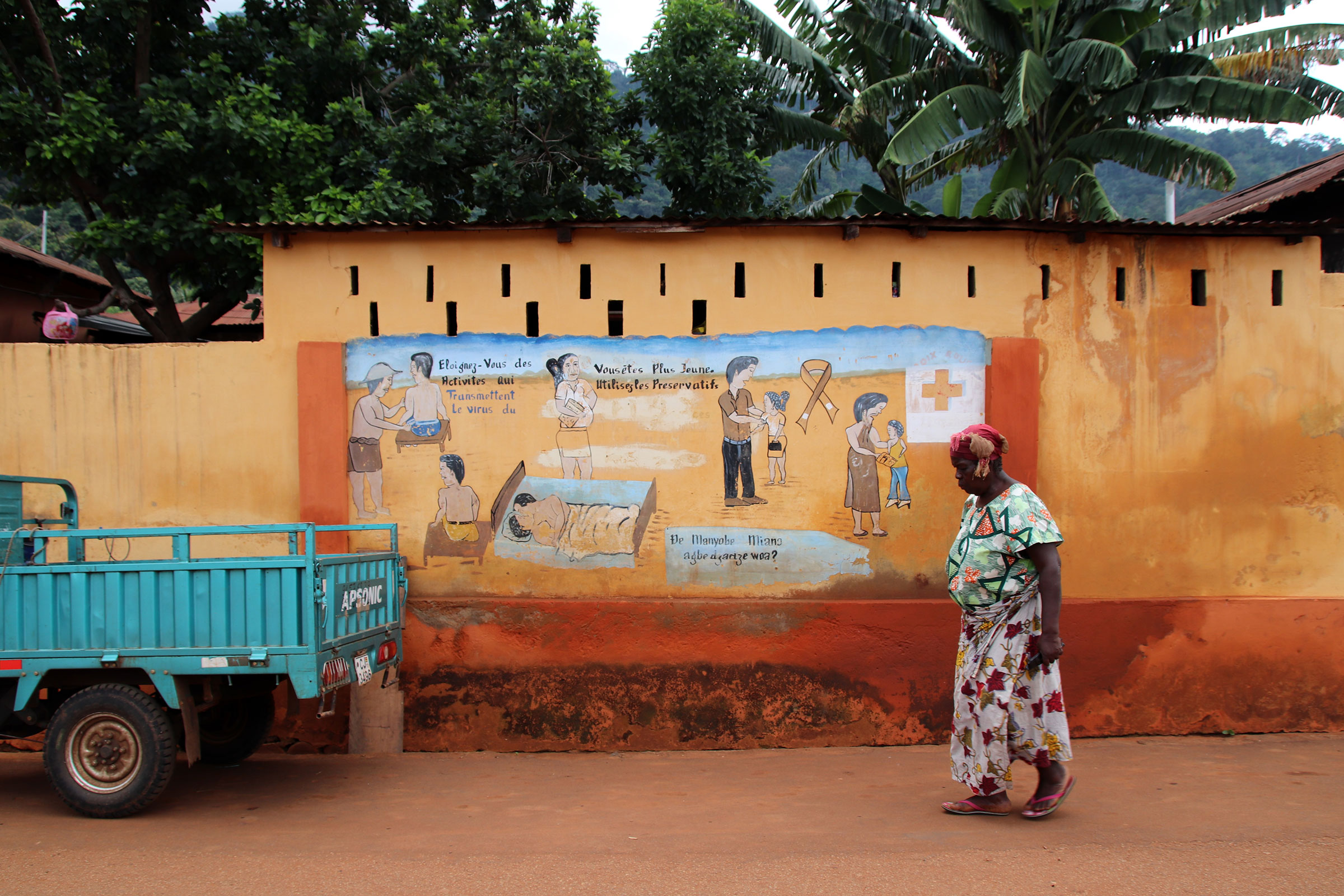 A woman walks past a large sign explaining how to protect yourself against HIV.