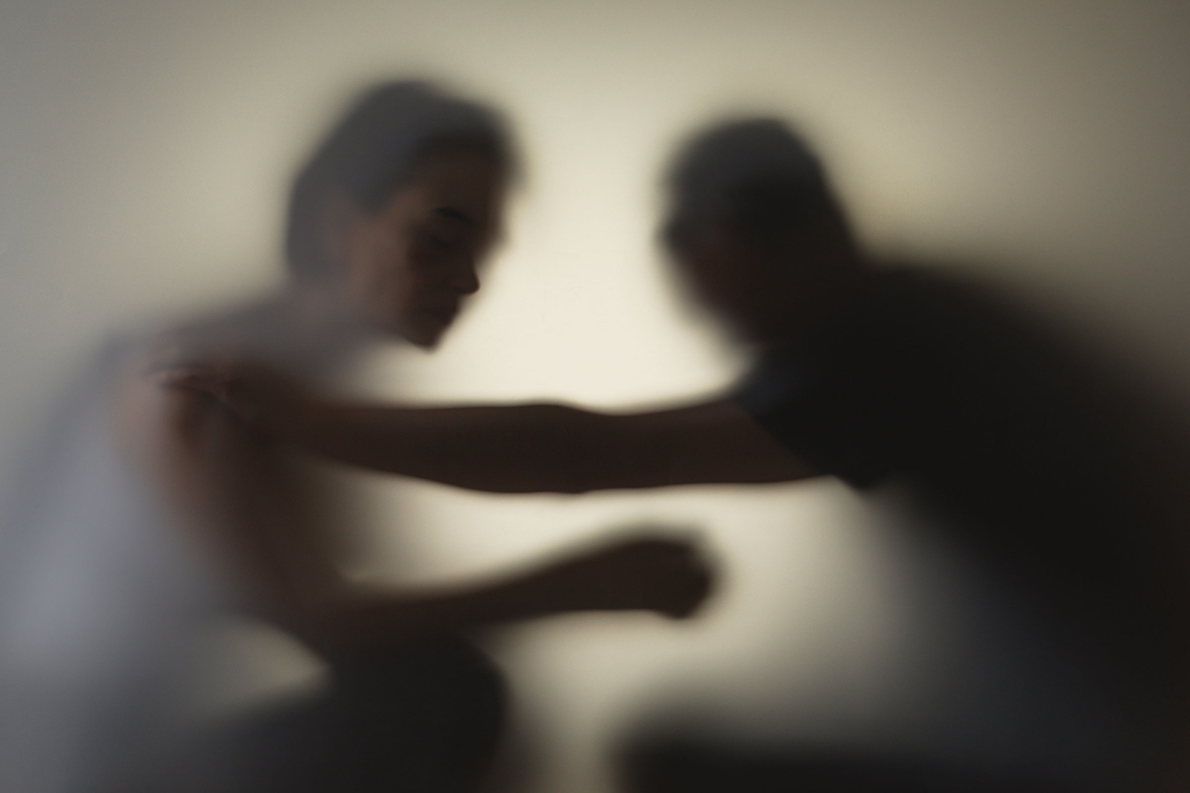 Two shadowy people in conflict.